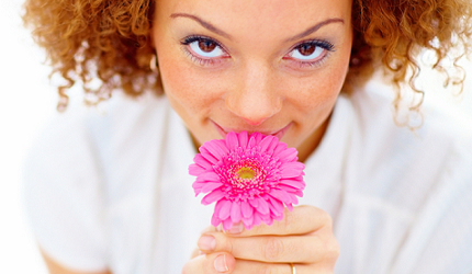 woman-smelling-pink gerbera flower